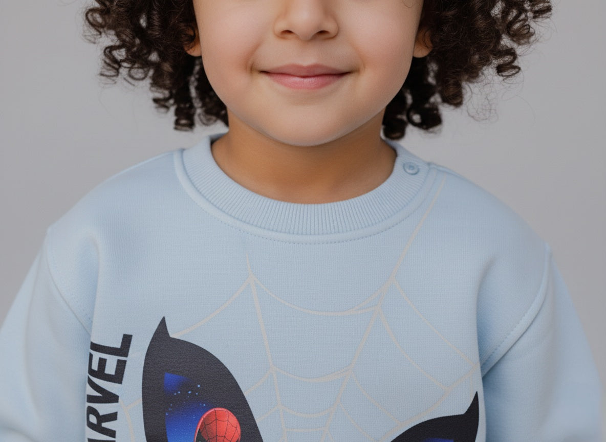 Child wearing a light blue Marvel sweatshirt with Spider-Man design on a gray background
