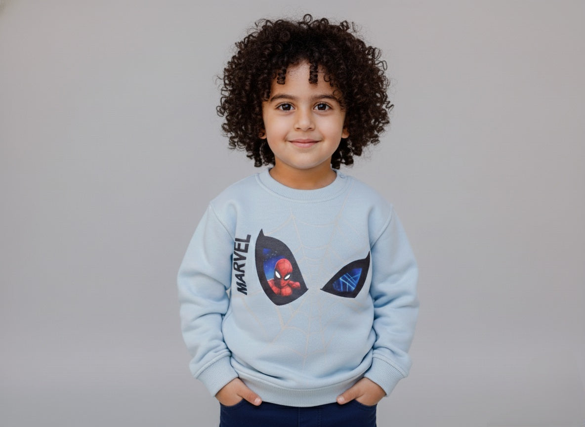 Child wearing a light blue Marvel sweatshirt with a Spider-Man design on a gray background