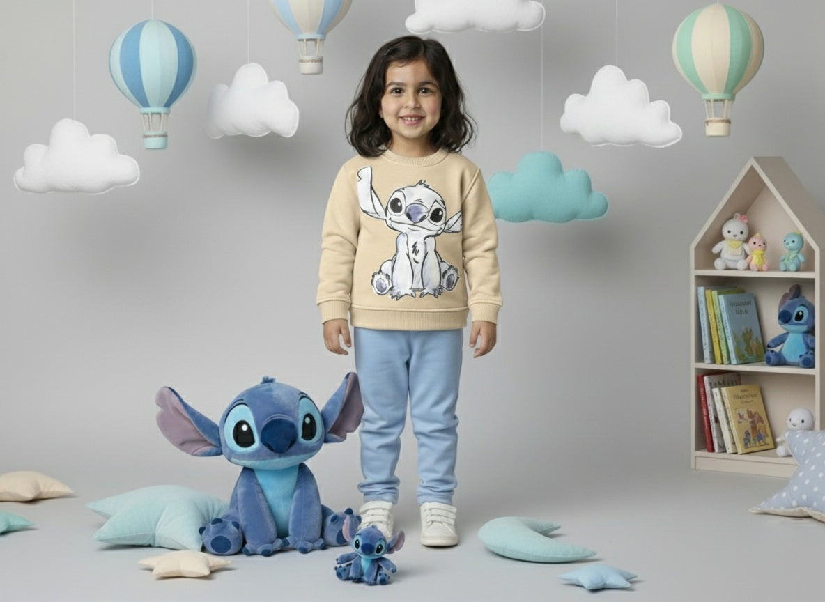 Child wearing a beige sweater with a stitch cartoon character, standing in a room with toys and decorations.