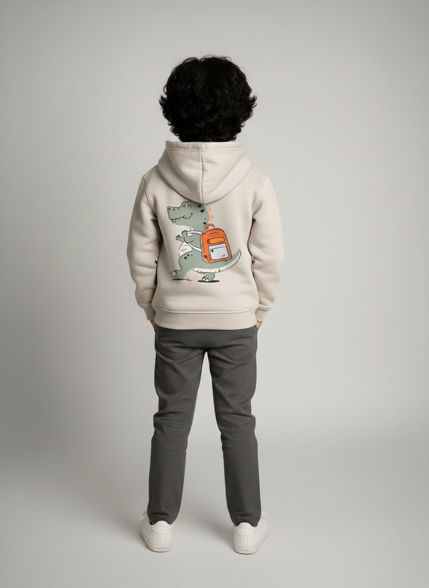 Child wearing a gray hoodie with a graphic design on the back, standing against a plain background