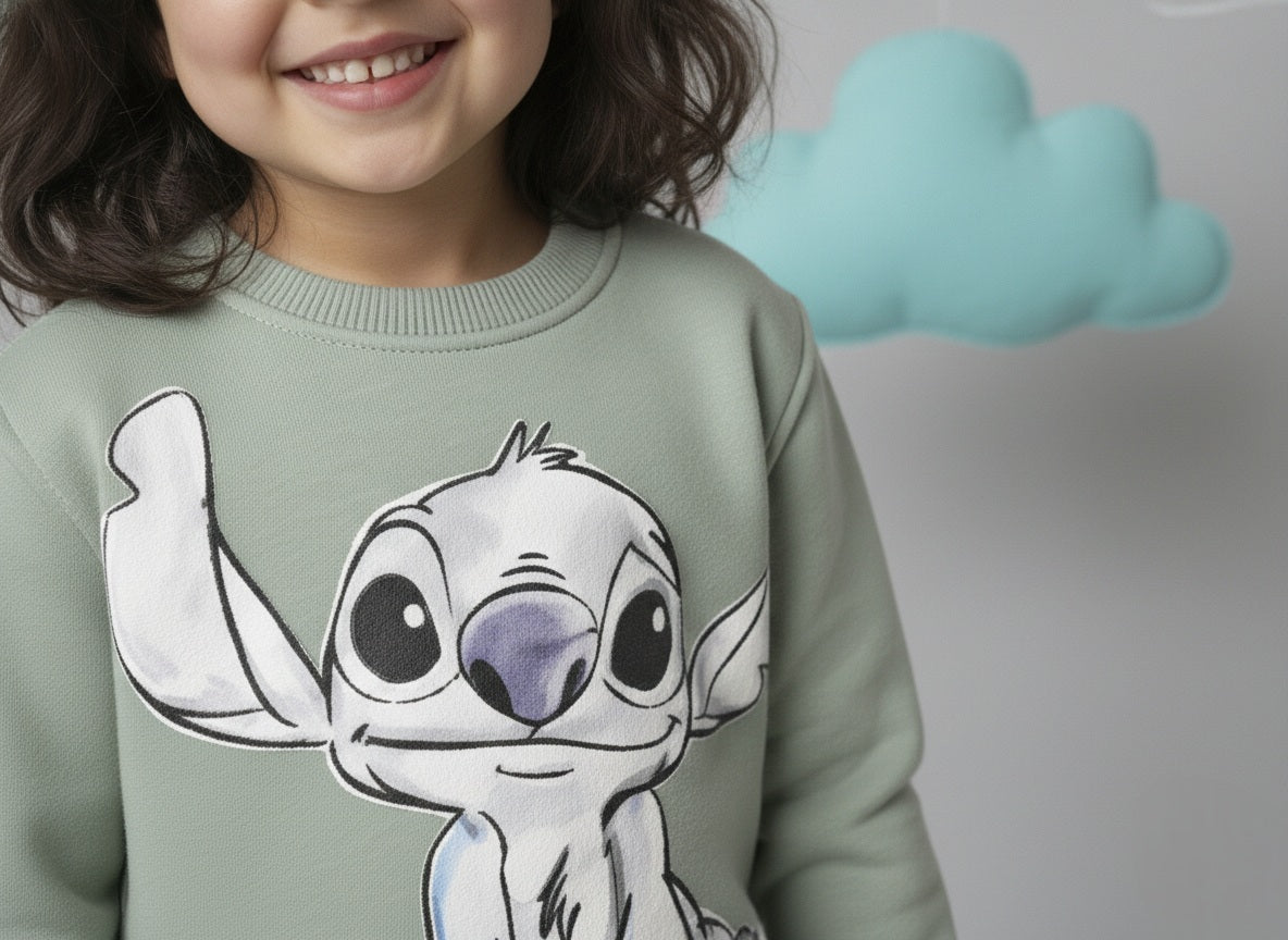 A girl wearing a mint green sweatshirt with a cute stitch design, standing against a plain background.