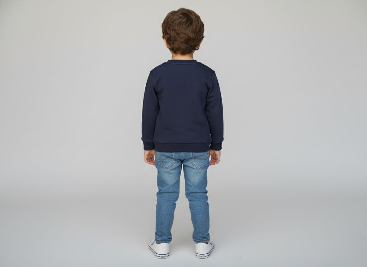 Child wearing a navy sweatshirt and blue jeans on a plain background