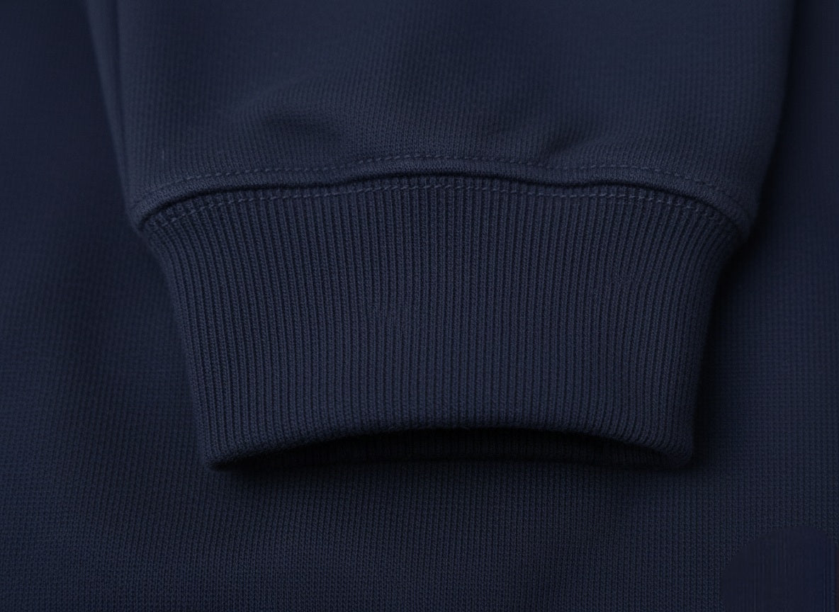 Close-up of a navy blue sweater sleeve on a dark background