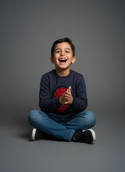 Child sitting on a gray background wearing a navy blue sweatshirt with a Spider-Man logo- Zoonikid
