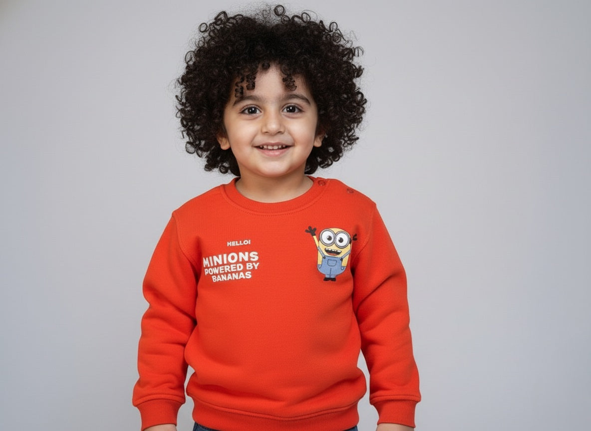 Child wearing an orange sweatshirt with a cartoon character on a gray background